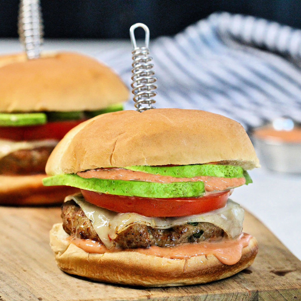 Turkey burgers with cheese, tomato and avocado.