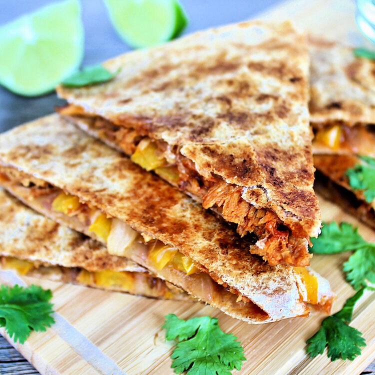 pulled chicken quesadillas stacked on a board