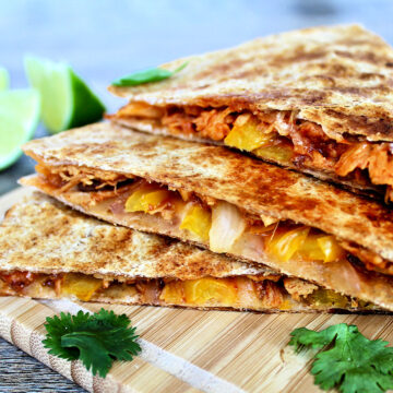 pulled chicken quesadillas stacked on a board