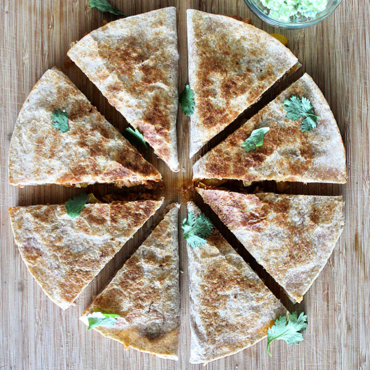 pulled chicken quesadillas cut up on a board