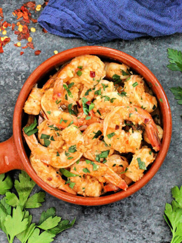 Overhead shot of Spanish garlic shrimp in a brown dish.