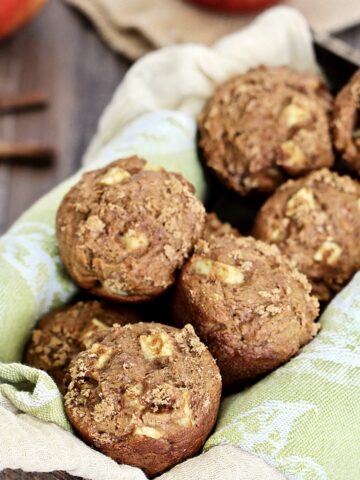 Basket of spiced apple muffins on a green napkin.