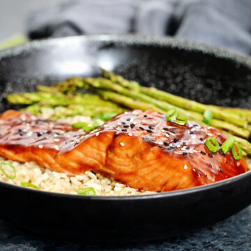 air fryer salmon teriyaki on a bowl with brown rice and asparagus.