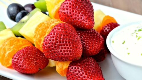 Rainbow Fruit Kabobs on a white platter.