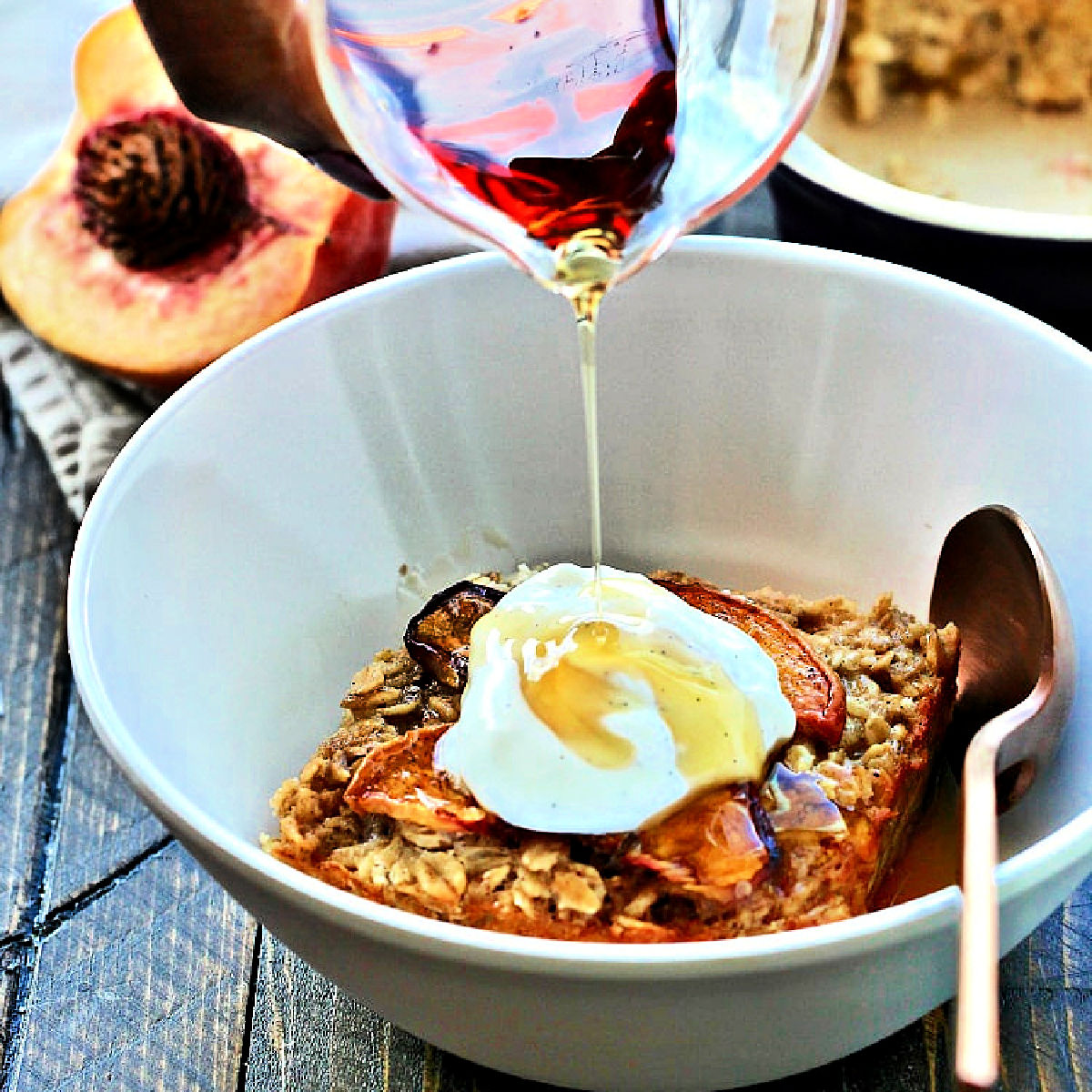 Peach baked oatmeal topped with yogurt and maple syrup.