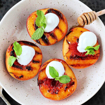 Grilled peaches with Greek yogurt in a white bowl.