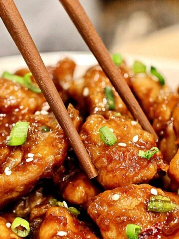 Air Fryer General Tso's Chicken with a pair of chopsticks picking up a piece.