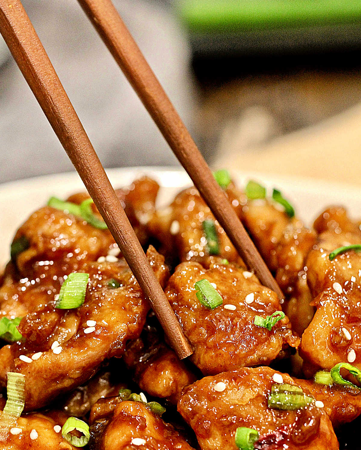 Picking up a piece of Air Fryer General Tso's Chicken with a pair of chopsticks.