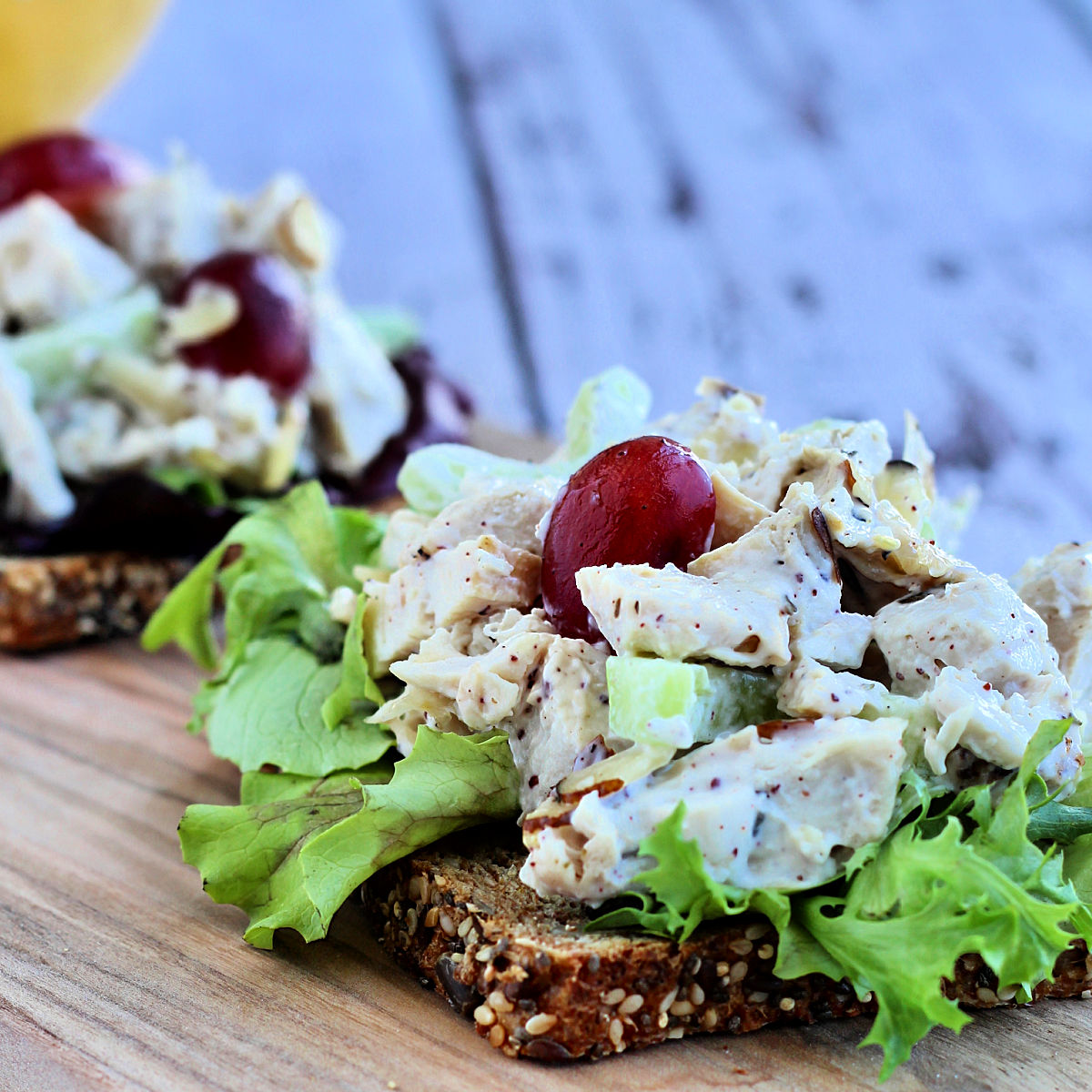 Chicken salad with grapes and almonds on a slice of multigrain bread.