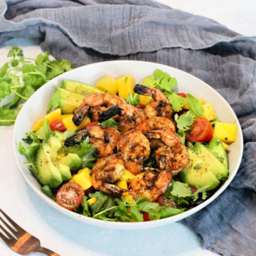 Grilled Shrimp Salad in a white bowl surrounded by a gray napkin