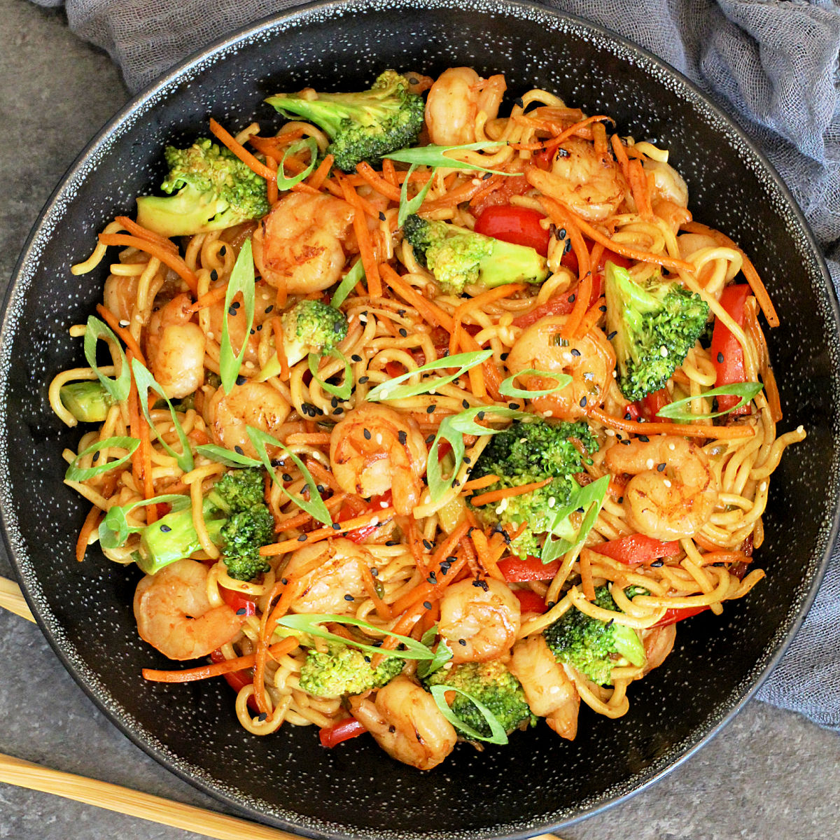 Overhead of Shrimp Stir Fry with Noodles in a black bowl.