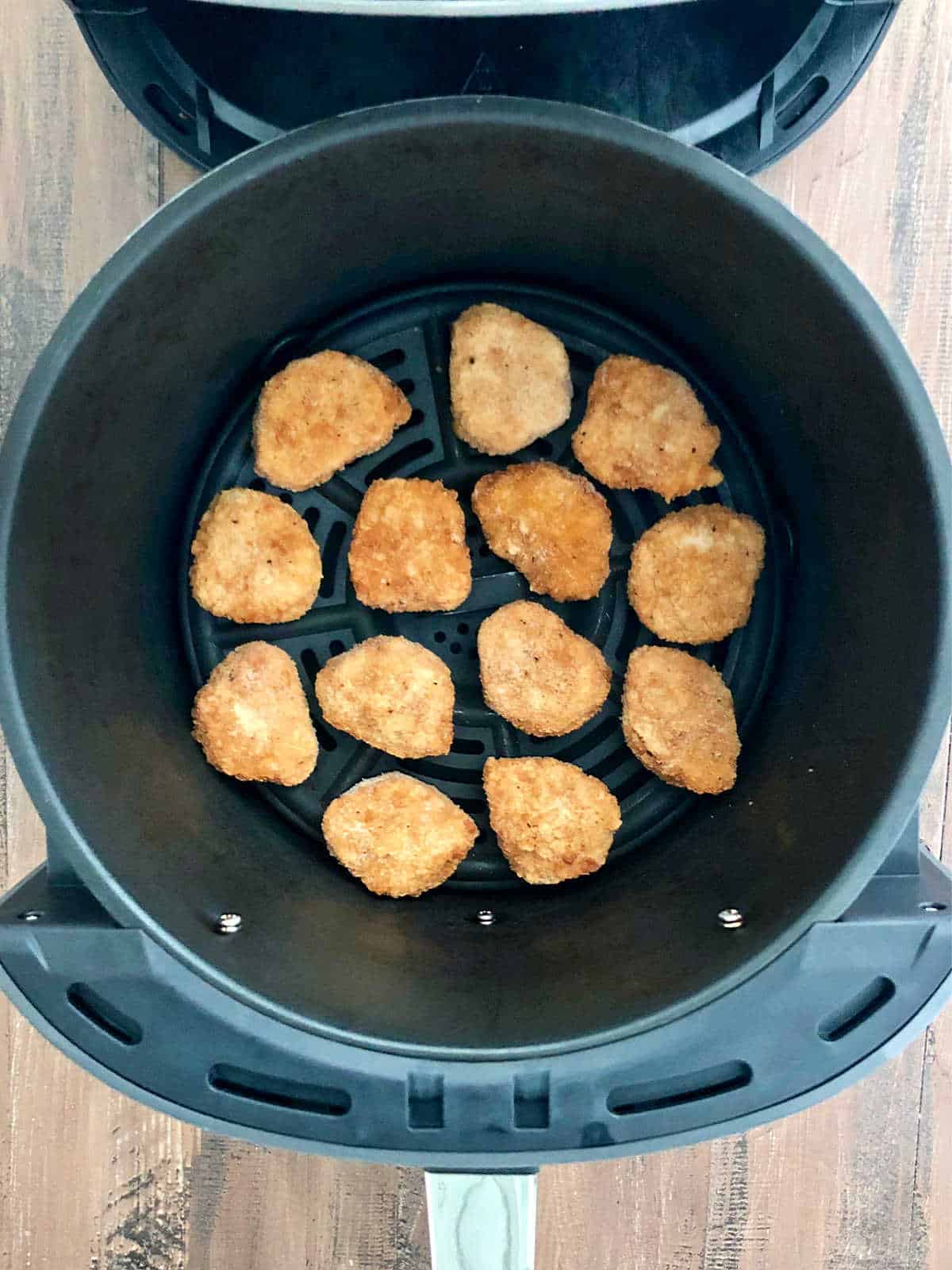 Chicken nuggets in air fryer basket.