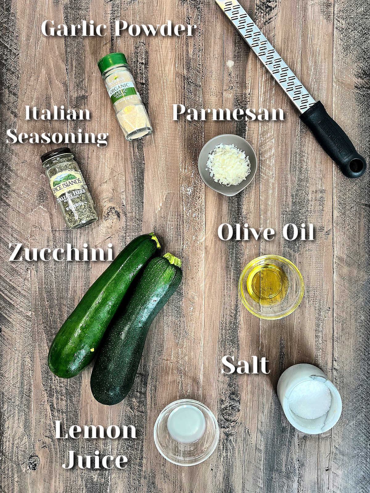 Ingredients for air fryer zucchini on a brown wooden board.