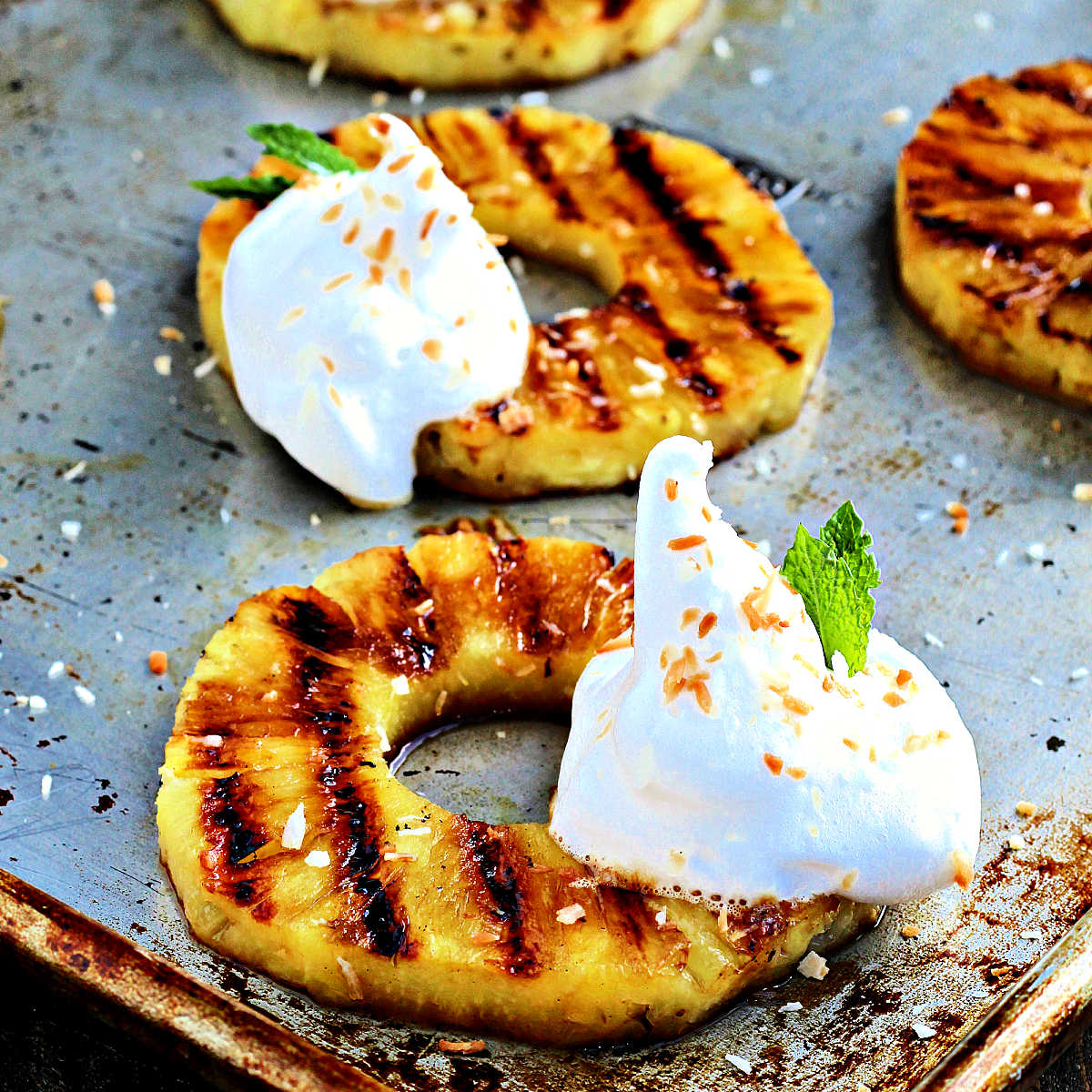 Grilled pineapple rings with dollops of aquafaba whipped cream.