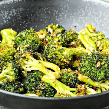 Sesame roasted broccoli in a black bowl.