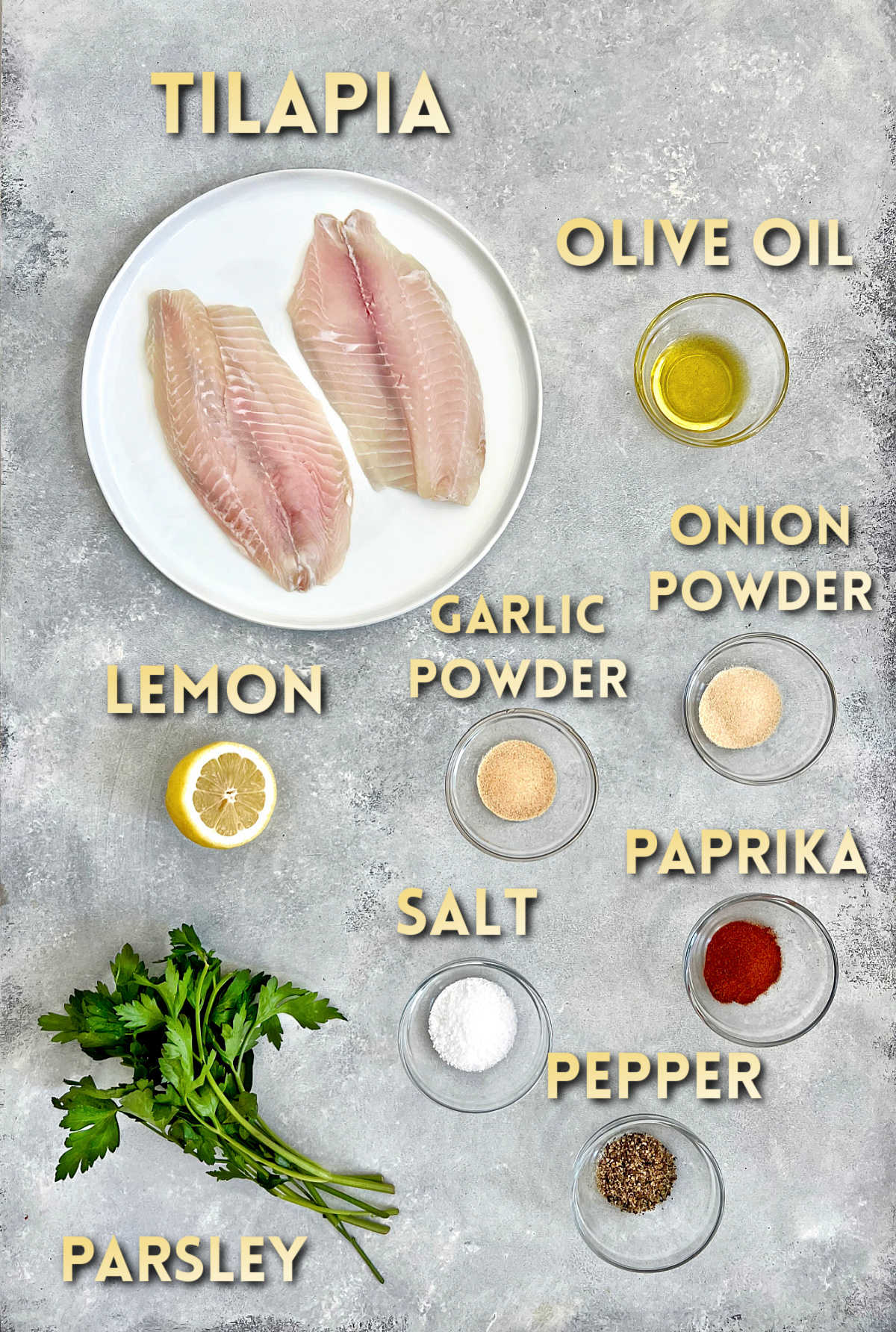 Ingredients for air fryer tilapia on a gray board.