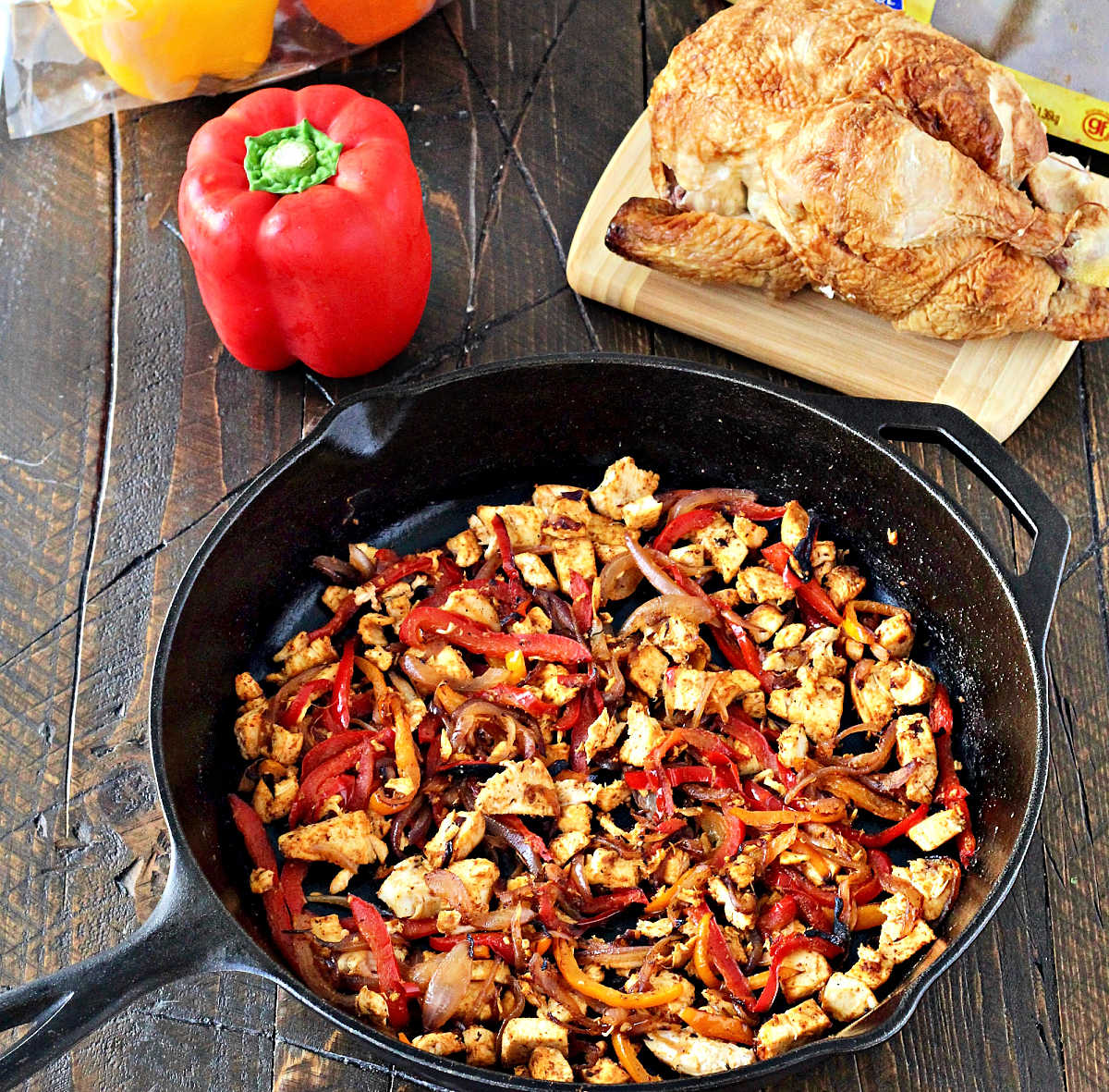 Chicken and bell peppers in a cast iron skillet.