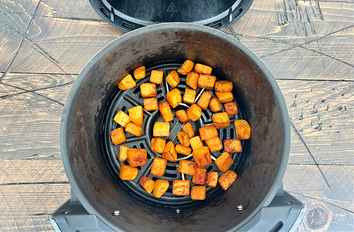 Cooked butternut squash in air fryer basket. 