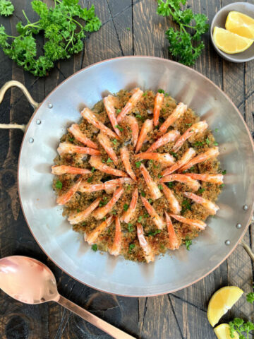 Overhead of shrimp oreganata arranged in a copper pan
