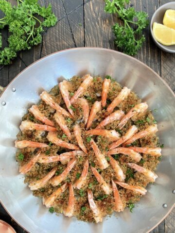 Overhead of shrimp oreganata arranged in a copper pan