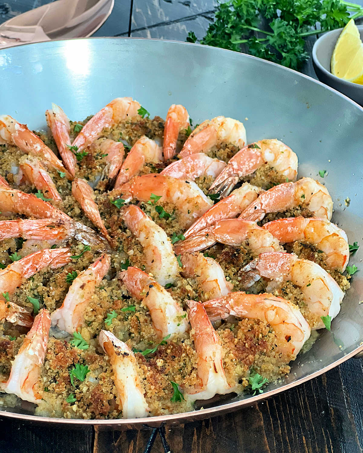 Side shot of shrimp oreganata arranged in a copper pan