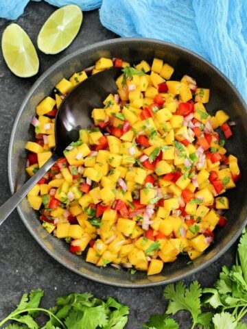 Mango salsa in a black bowl.