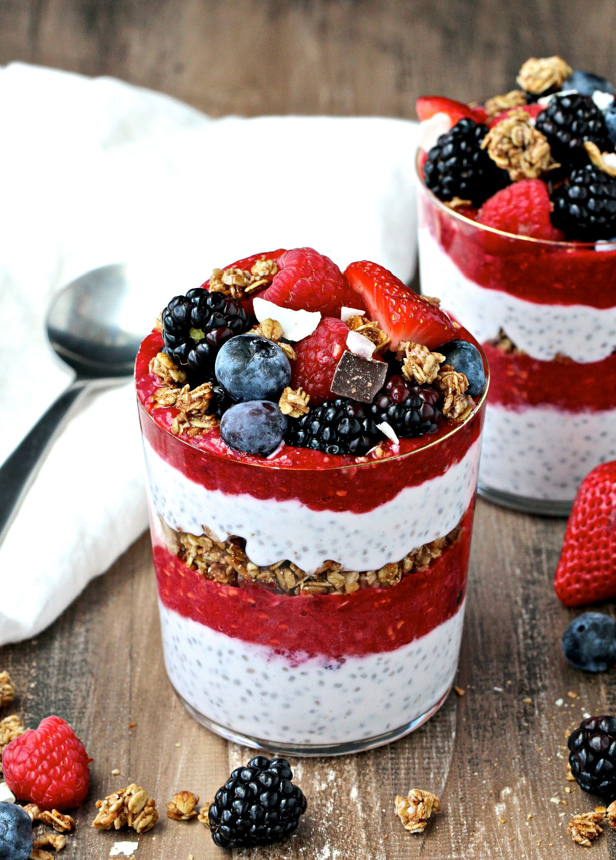 2 Berry Chia Pudding Parfaits on a wooden board.