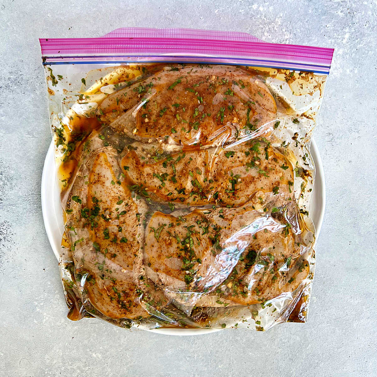 Marinating chicken in a plastic bag.