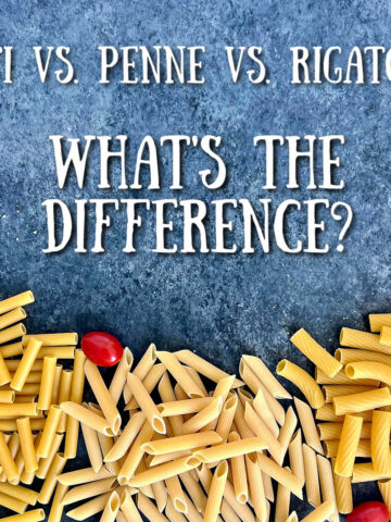 Different types of pasta on a gray board with the words "Ziti vs. Penne vs. Rigatoni- What's the Difference?"
