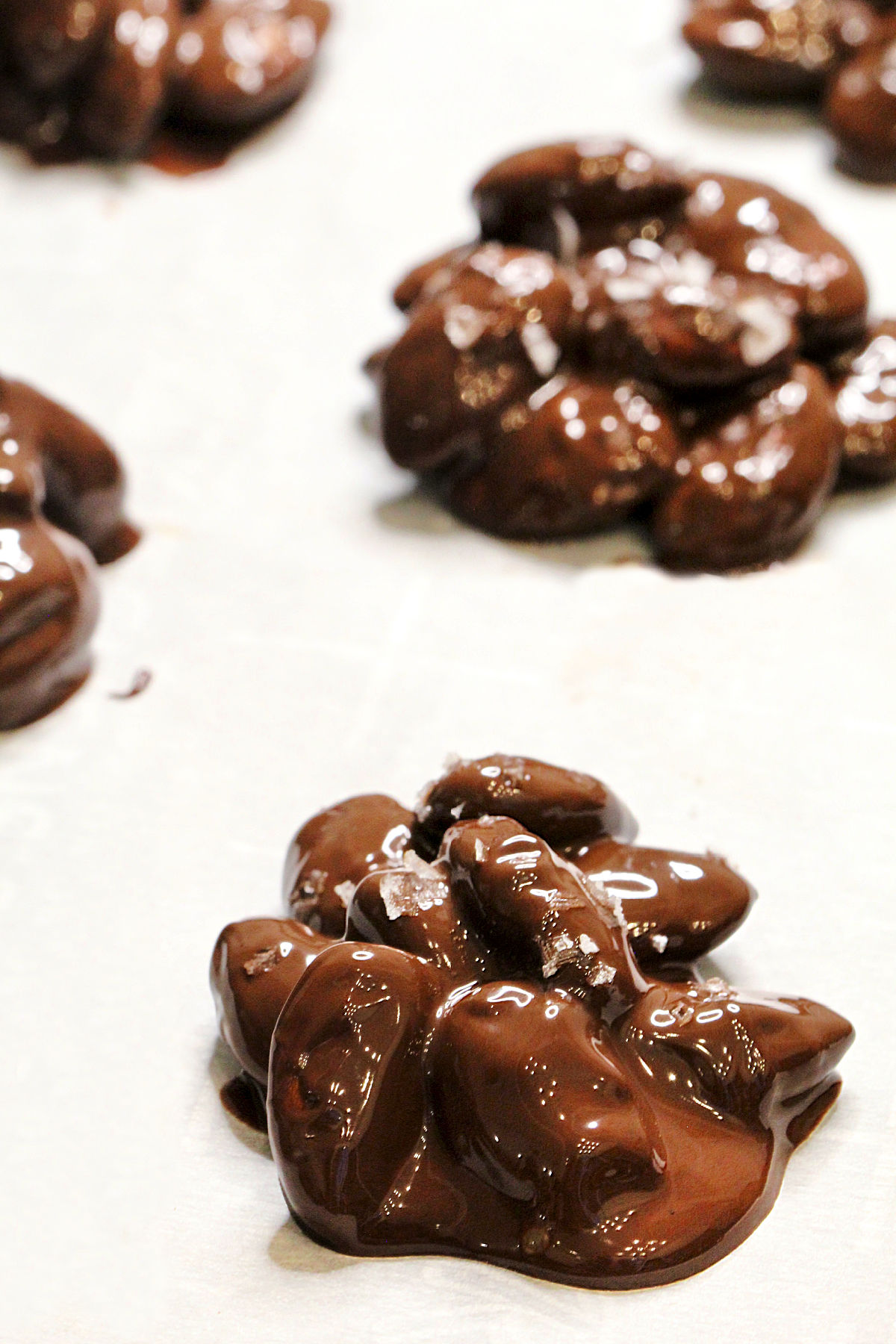 Chocolate almond clusters on wax paper.