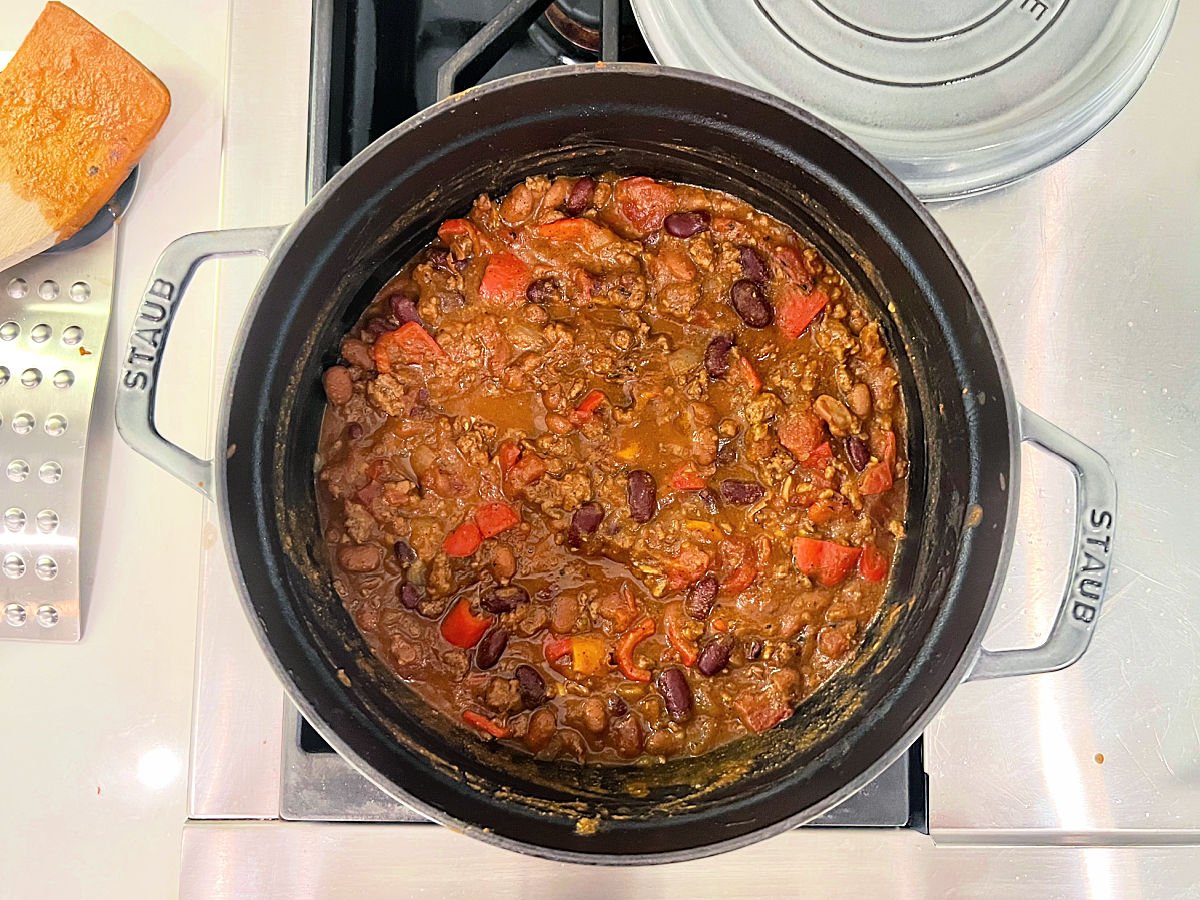 Pumpkin chili with beef cooking in a Dutch oven.
