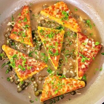 Vegan tempeh piccata finished in skillet with lemon caper sauce