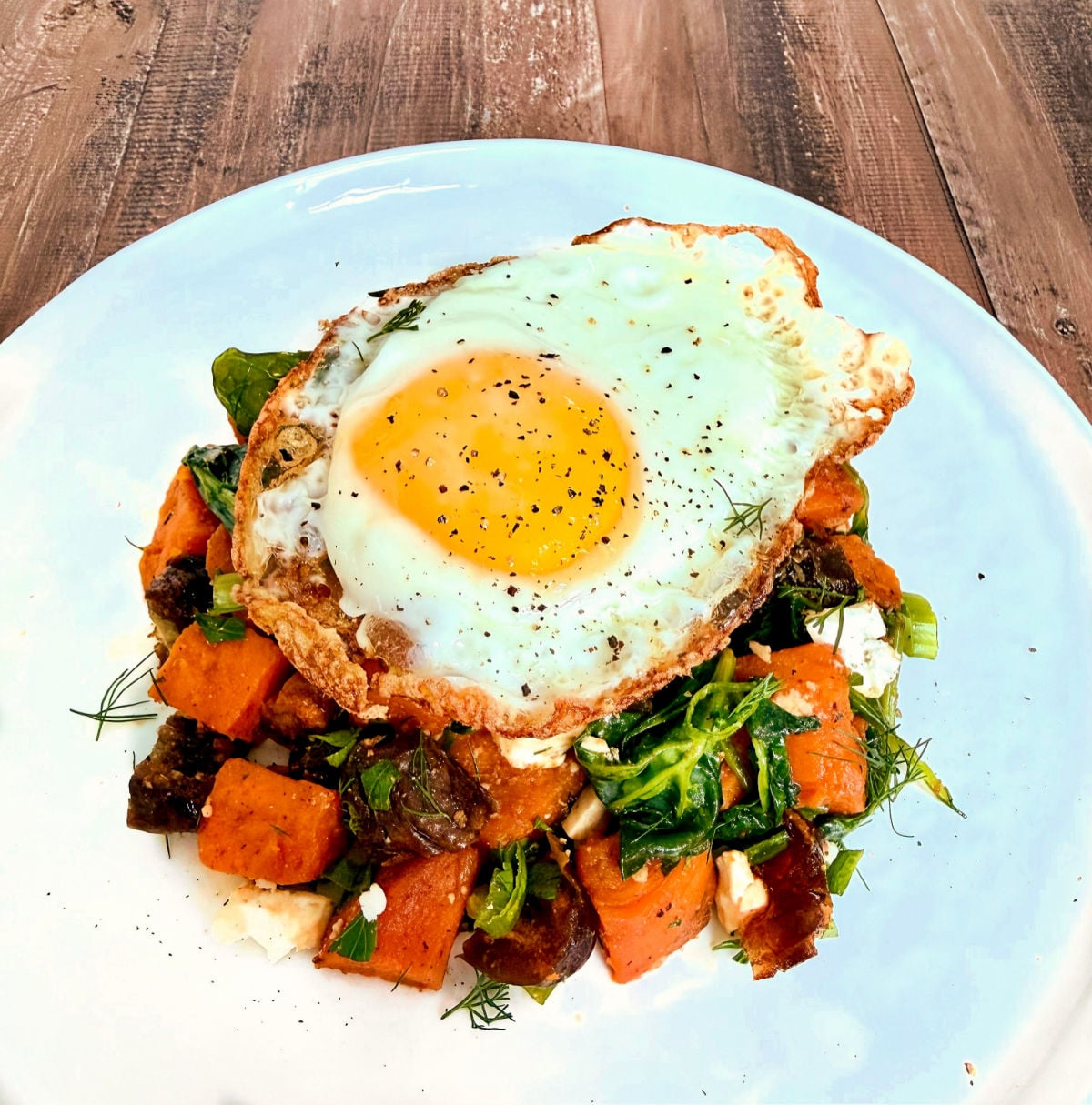 Serving of Mediterranean Sweet Potato Breakfast Hash with a fried egg on top